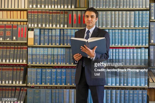 hispanic businessman doing research in library - law library stock pictures, royalty-free photos & images
