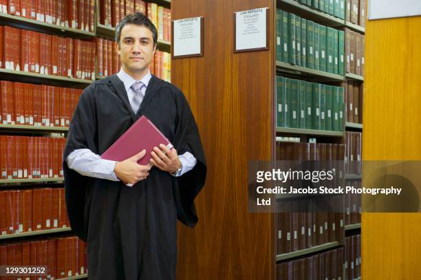 hispanic man doing research in library - robe stockfoto's en -beelden
