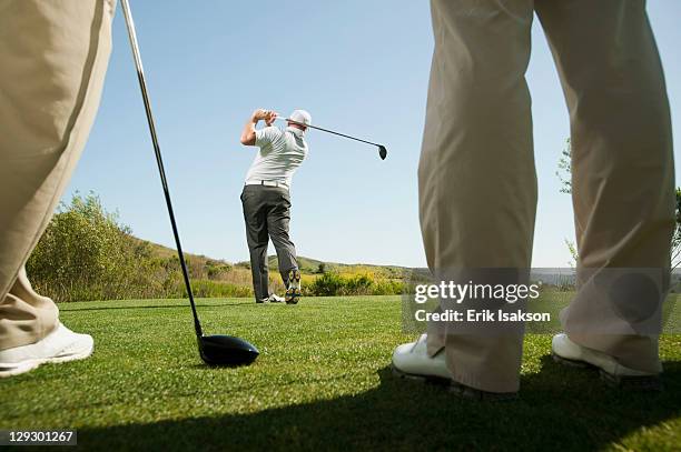 men playing golf together on golf course - playing golf stock pictures, royalty-free photos & images