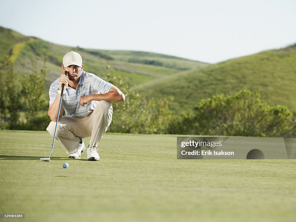 Caucasian golfer checking the ground on golf course