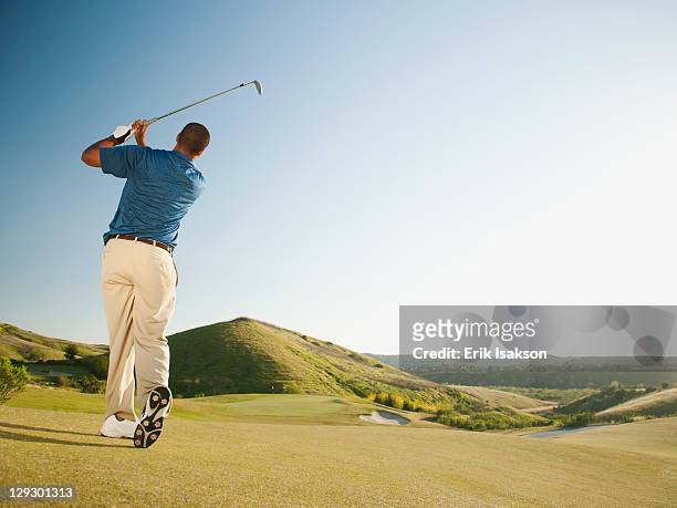 black golfer swinging golf club - swing de golf fotografías e imágenes de stock