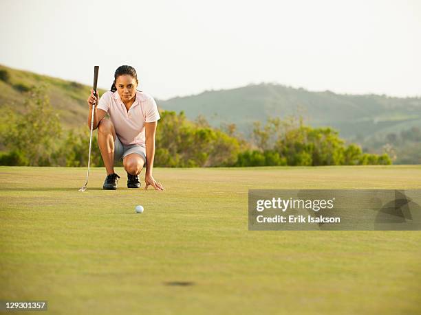 mixed race woman checking ground on golf course - golfer putting stock pictures, royalty-free photos & images