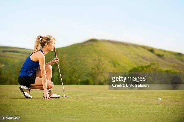caucasian woman checking ground on golf course - golfer putting stock pictures, royalty-free photos & images