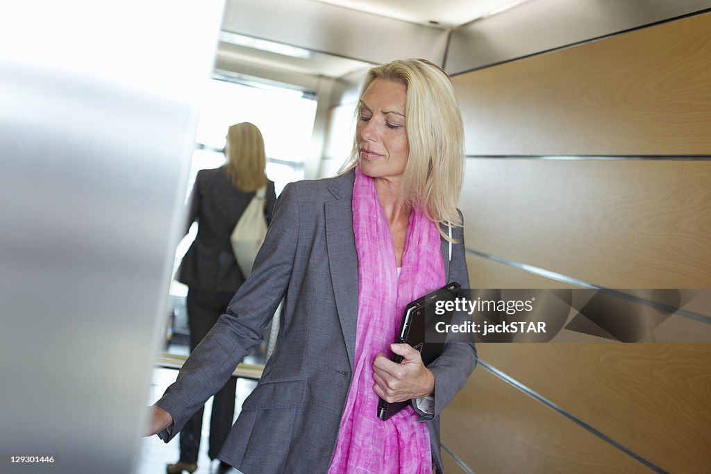 Businesswoman carrying tablet in office