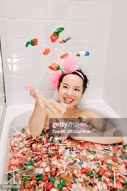 mixed race woman taking a bath in candy - beautiful woman bath photos et images de collection