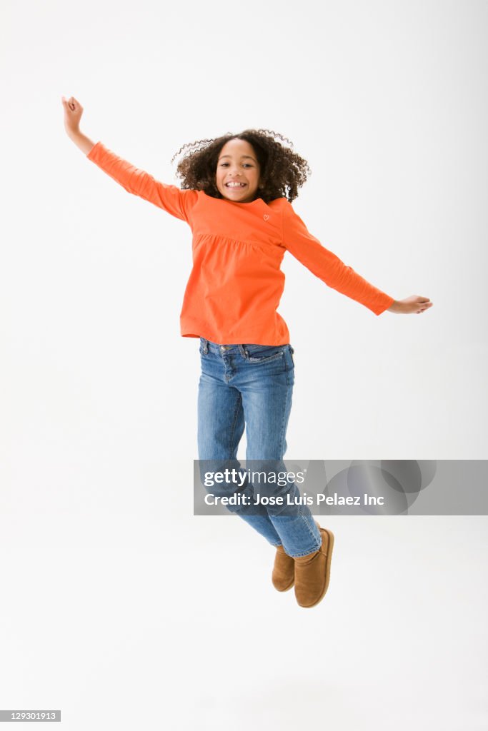 Mixed race girl cheering and jumping