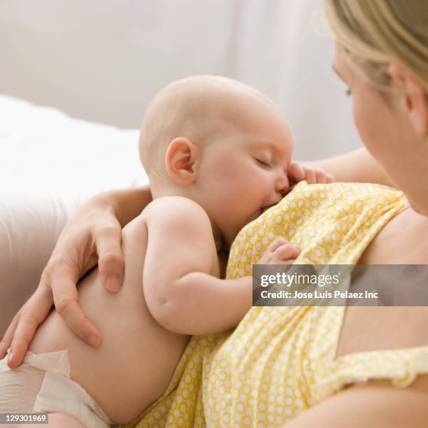 caucasian mother breast feeding baby boy - still stock-fotos und bilder