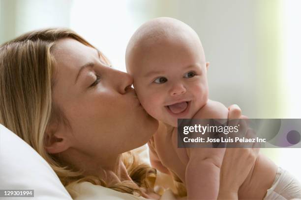 caucasian mother kissing baby boy - chest kissing stockfoto's en -beelden