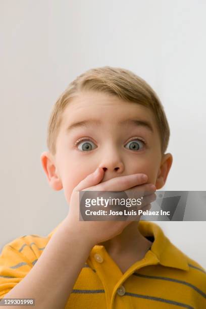 surprised caucasian boy covering mouth - scared boy imagens e fotografias de stock