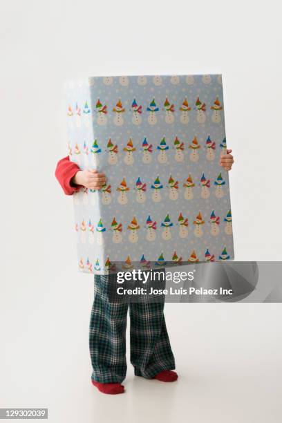 caucasian boy holding large christmas gift - boy gift stock-fotos und bilder