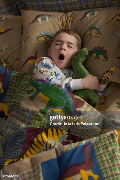 caucasian boy sleeping in bed - sleeping boys stockfoto's en -beelden