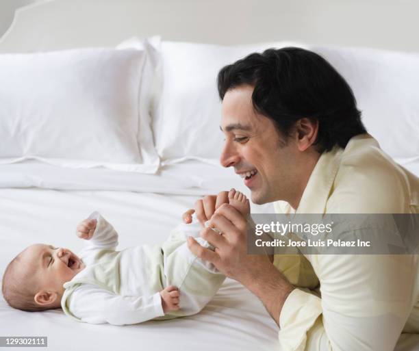 caucasian father and son playing with baby son - tickling feet - fotografias e filmes do acervo