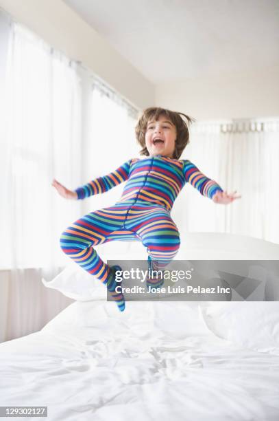 caucasian boy jumping on bed - children jumping bed stock-fotos und bilder