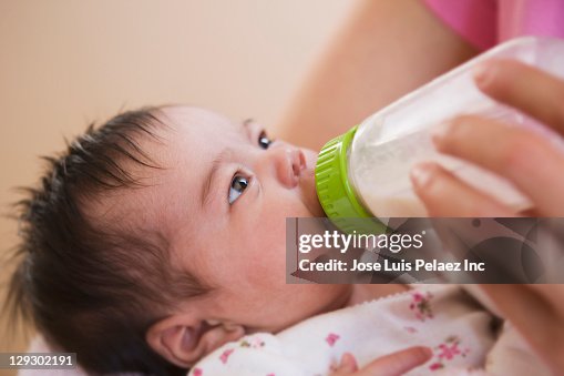 Mother feeding newborn baby daughter Mother feeding newborn baby daughter