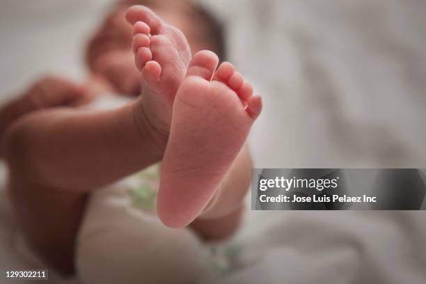 close up of mixed race newborn baby girl's feet - enkel stockfoto's en -beelden