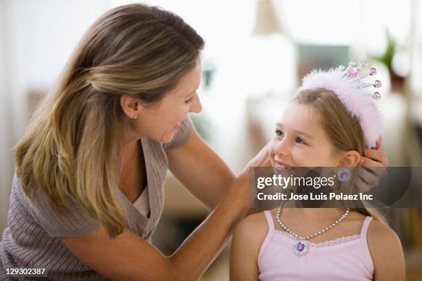 caucasian mother adjusting tiara on daughter - adjusting hair stock pictures, royalty-free photos & images