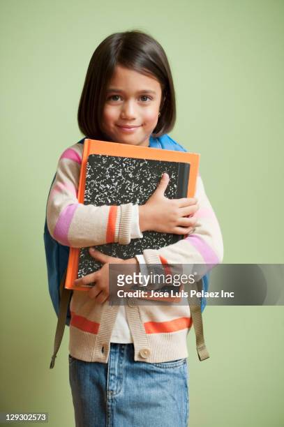 mixed race girl carrying school books - material escolar fotografías e imágenes de stock
