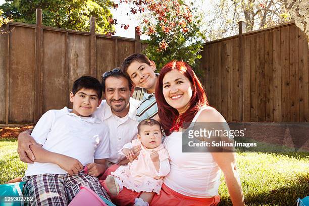 hispanic family sitting together in backyard - day 4 stock-fotos und bilder