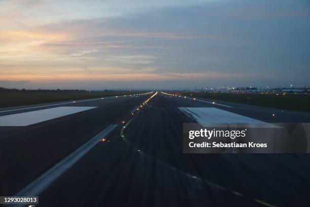 on the runway of vienna international airport,dusk, schwechat, austria - flughafen wien stock-fotos und bilder