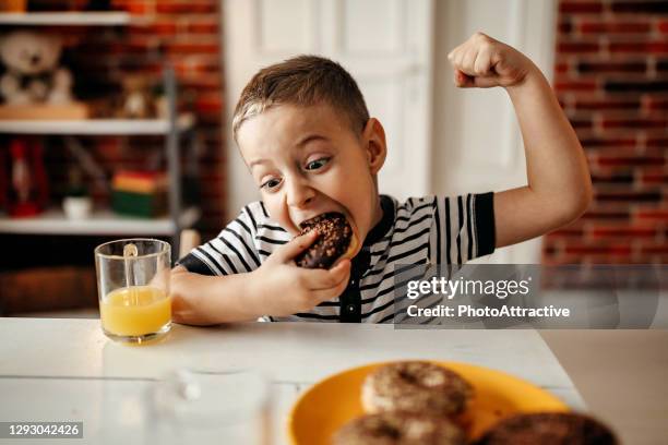 leuk zoet blond kind, dat en donuts speelt en eet - fat boys stockfoto's en -beelden