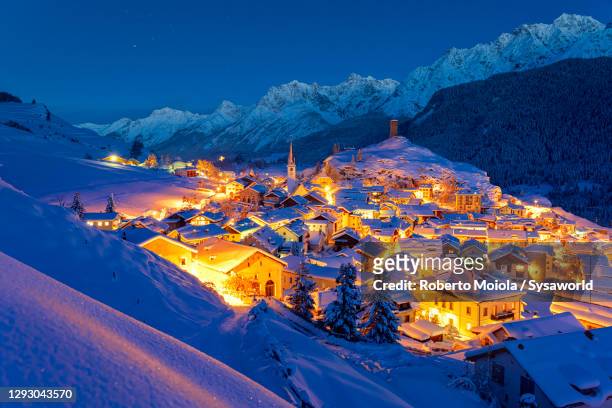 dusk on ardez village covered with snow, switzerland - village stock-fotos und bilder