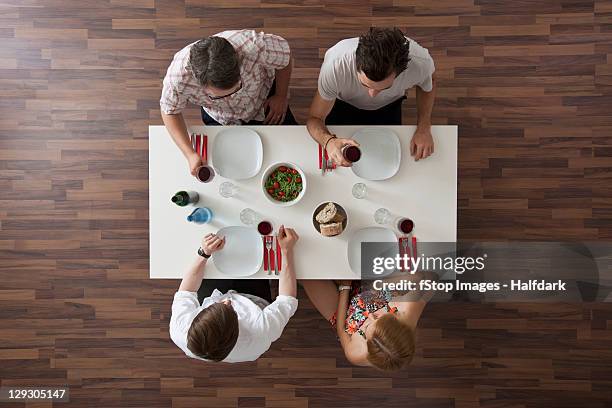 two friends raising their glasses in a toast at a dinner party, overhead view - friends toasting above table stock pictures, royalty-free photos & images