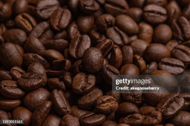 energy stimulant and smooth java concept with full frame photograph of piled roasting coffee beans backgrounds - cereal plant foto e immagini stock