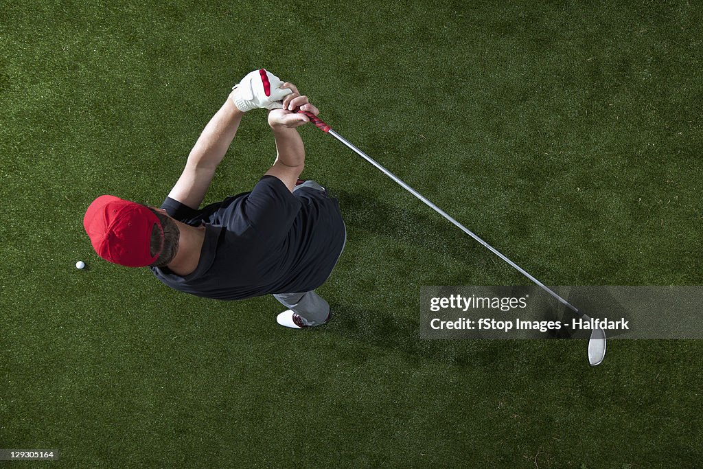 A golfer swinging a golf club, overhead view