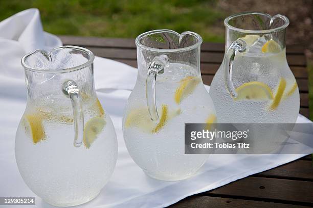 three pitchers of ice water with lemon slices - jug stock pictures, royalty-free photos & images