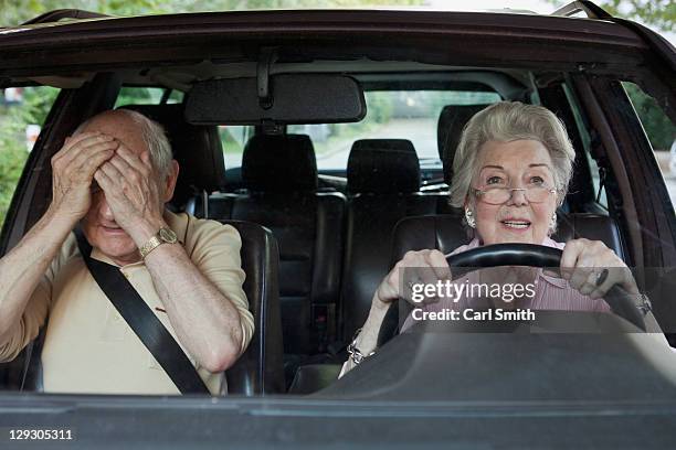 woman has trouble driving while man in passenger seat despairs - steering wheel stockfoto's en -beelden