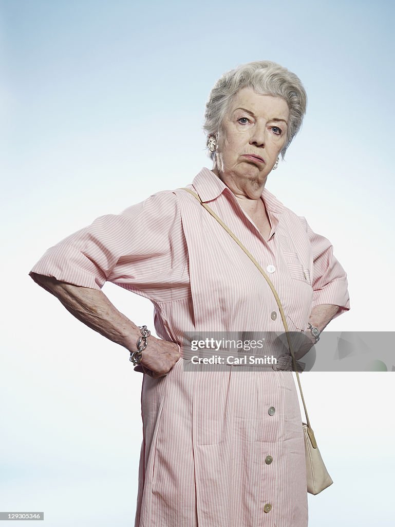 Senior woman with hands on her hips looking disgruntled 