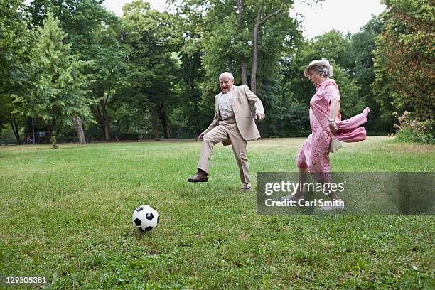 senior man and woman play football in the park - park berlin stock-fotos und bilder