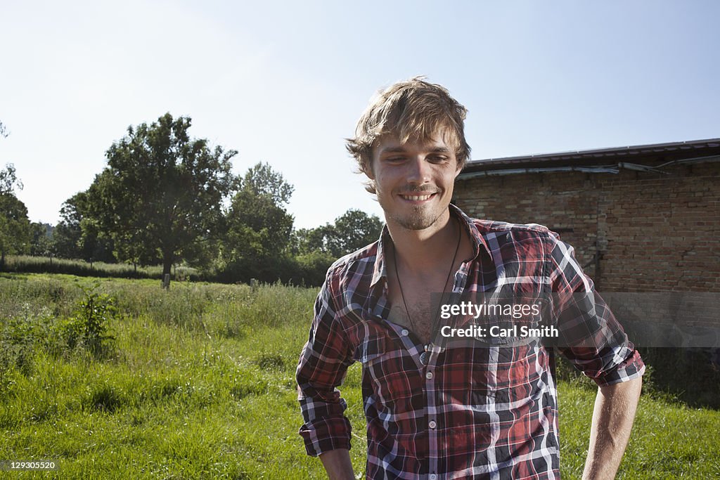 Guy in field with barn in background