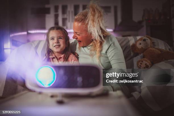 oma en kleinkind die projectorfilms met popcorn in avond thuisvoorraad letten - living projector stockfoto's en -beelden