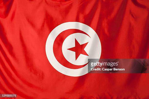 tunisia flag, red crescent moon and red star shape in a white circle with a red background - tunis stock pictures, royalty-free photos & images