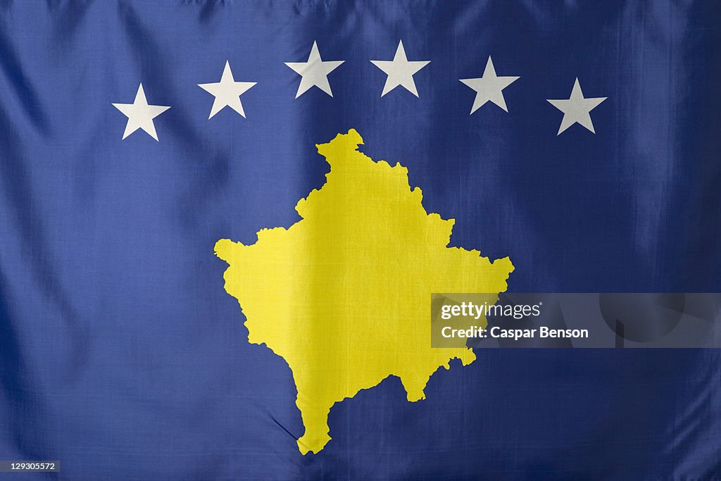 Kosovo flag, blue with a gold covered map of Kosovo under an arc of six white stars