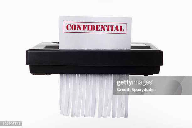 a document with confidential on it being shredded in a paper shredder - paper shredder on white stock pictures, royalty-free photos & images