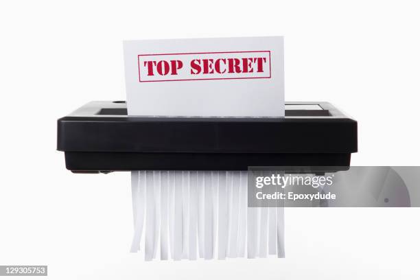 a document with top secret on it being shredded in a paper shredder - geschreddert stock-fotos und bilder