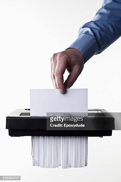 a man feeding a blank document into a paper shredder, close-up - paper shredder on white stock pictures, royalty-free photos & images