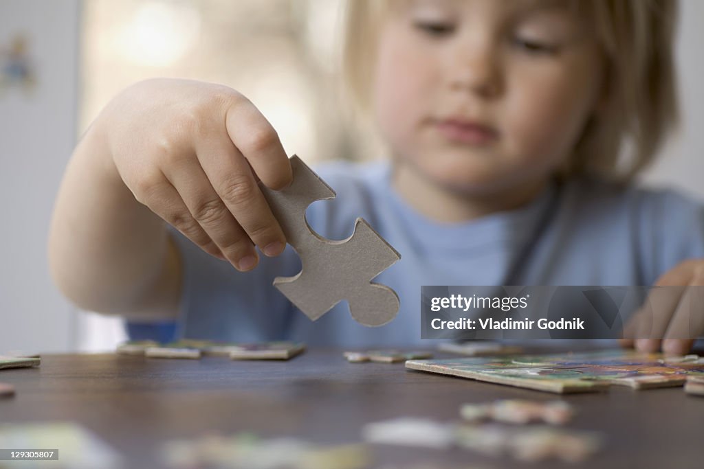 A young boy holding a puzzle piece