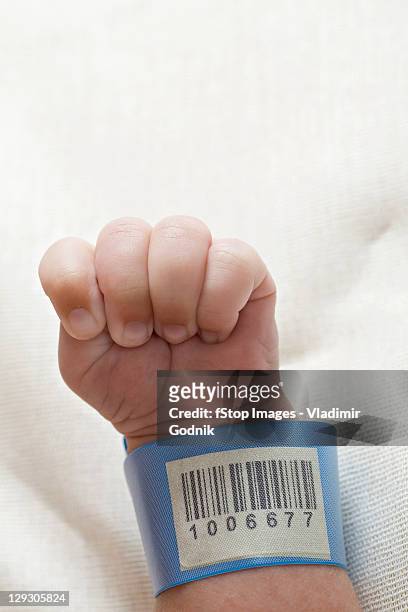 a hospital id bracelet on a baby's wrist - name tag fotografías e imágenes de stock