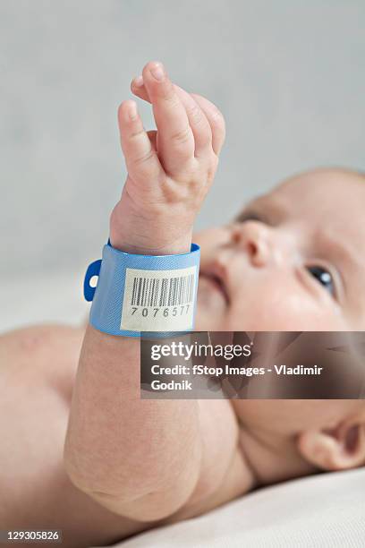 a baby with a hospital id bracelet her wrist, focus on wrist - hospital bracelet stock pictures, royalty-free photos & images