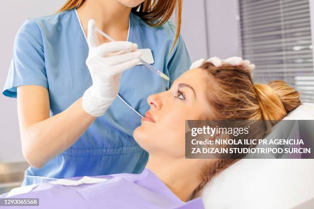 jeune belle femme dans le traitement à la chirurgie plastique et à la clinique faciale de correction. - correction fluid photos et images de collection