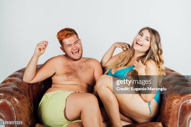 young man and woman laughing, on sofa, partially clothed - men wearing bras photos stock pictures, royalty-free photos & images