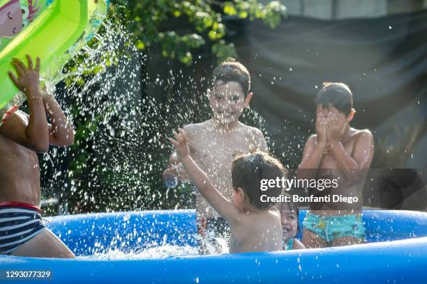 children playing in a swimming pool - いとこ ストックフォトと画像