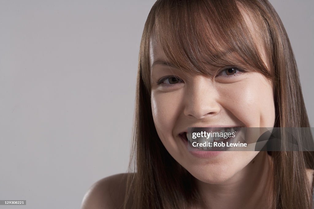 Portrait of young smiling woman, studio shot