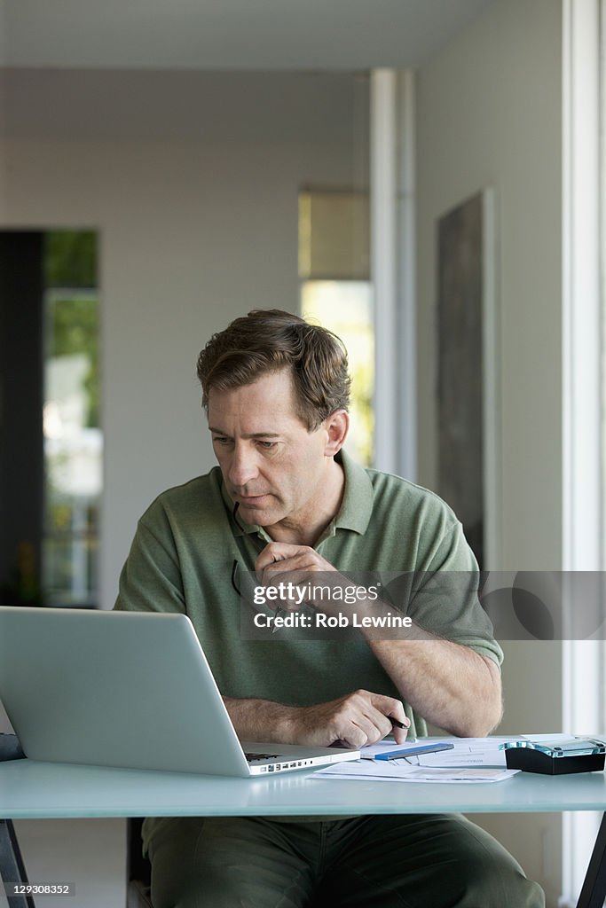 Mature man working on laptop at home