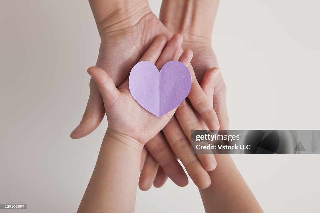 USA, Illinois, Metamora, Hands of mother and daughter (4-5) holding paper heart