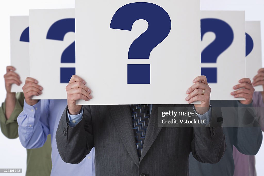 Multiplied businessman standing with question marks in fron of his face
