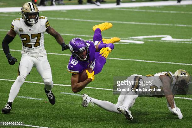 Justin Jefferson of the Minnesota Vikings is flipped by P.J. Williams of the New Orleans Saints during the second quarter at Mercedes-Benz Superdome...